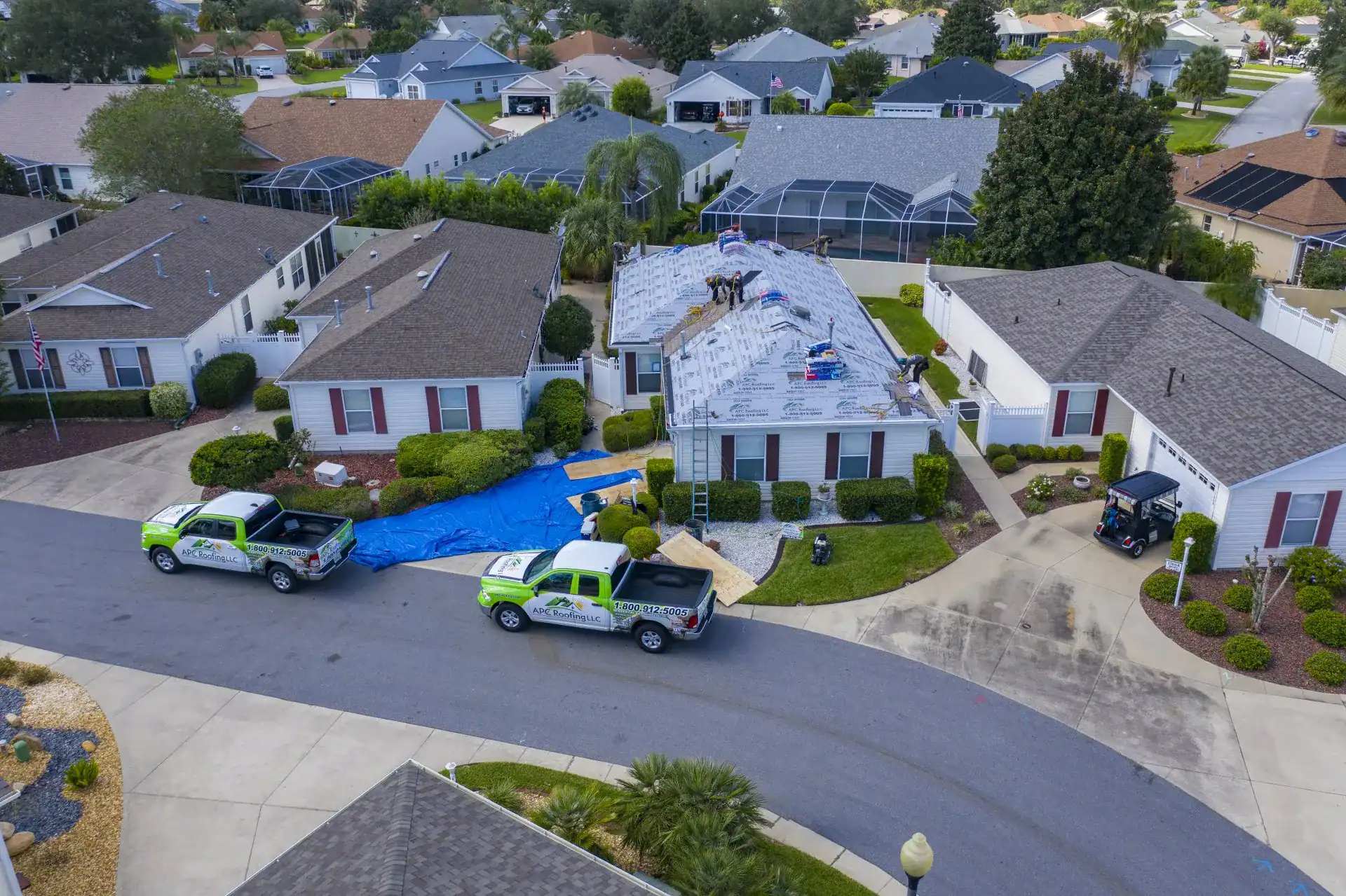 APC Roofing trucks at a home being re-roofed after a storm