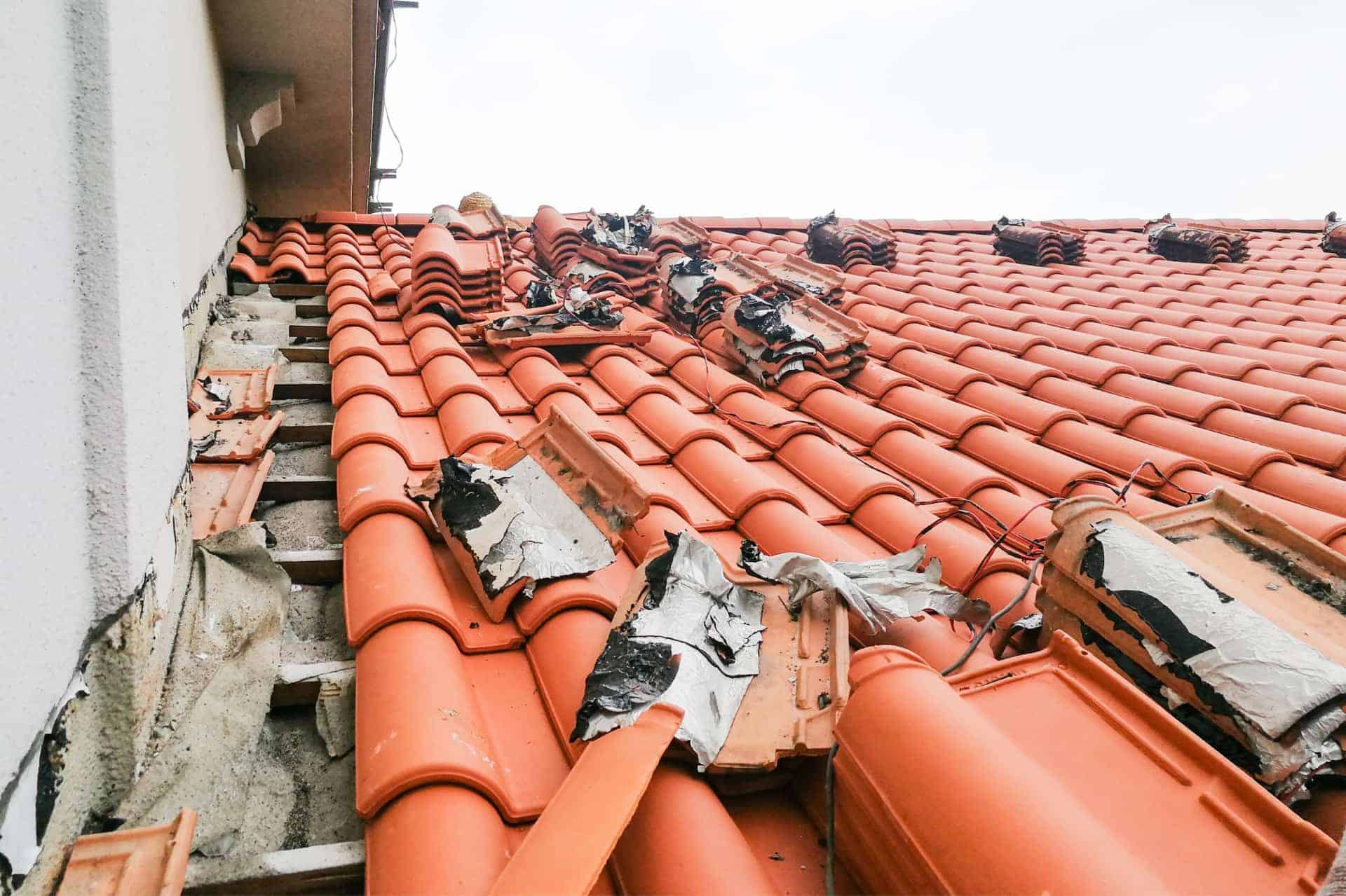 Broken clay roof tiles being removed for repair