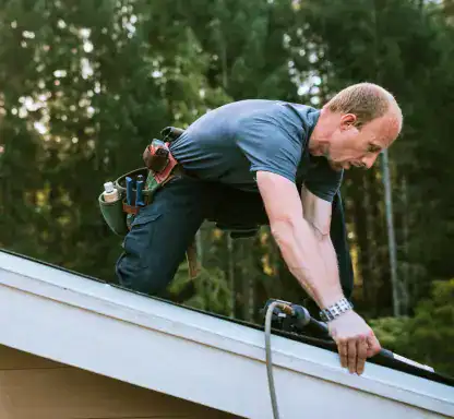 Roofers inspecting and repairing a residential roof for storm damage.