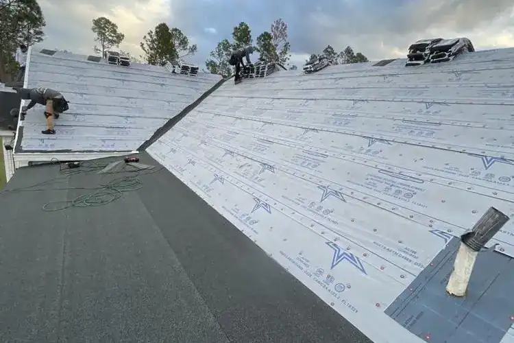 Installing roofing underlayment on a residential roof for weather protection.