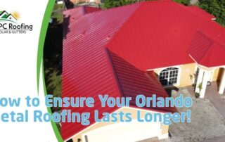 Aerial view of a house with a red metal roof, showing roofing installation process.