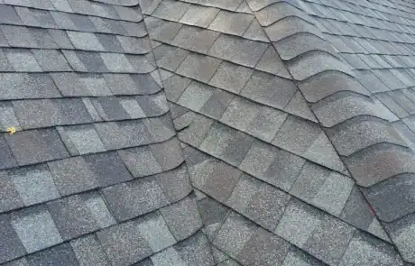 Close-up of asphalt shingles on a residential roof showing the pitch and valley intersections.