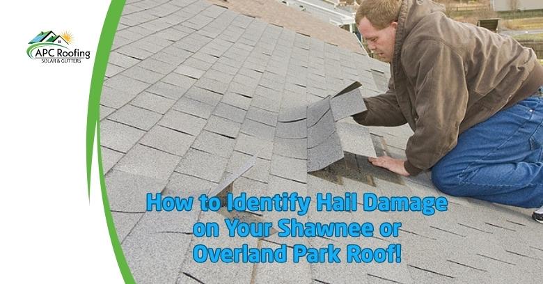 Roofing technician inspecting hail damage on a gray shingle roof in Overland Park.