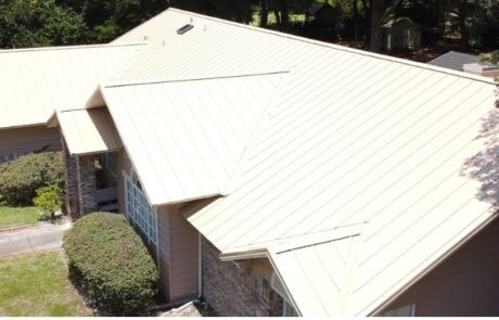 A metal roof with multiple vents and skylights on a residential building.