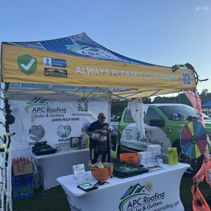 APC Roofing's Halloween booth with spider decorations, a prize wheel and an APC Roofing truck